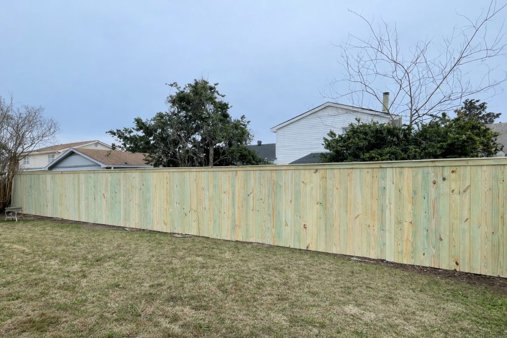 8-foot pressure-treated wood privacy fence installed in Madisonville, Louisiana, featuring vertical board construction and full backyard enclosure.