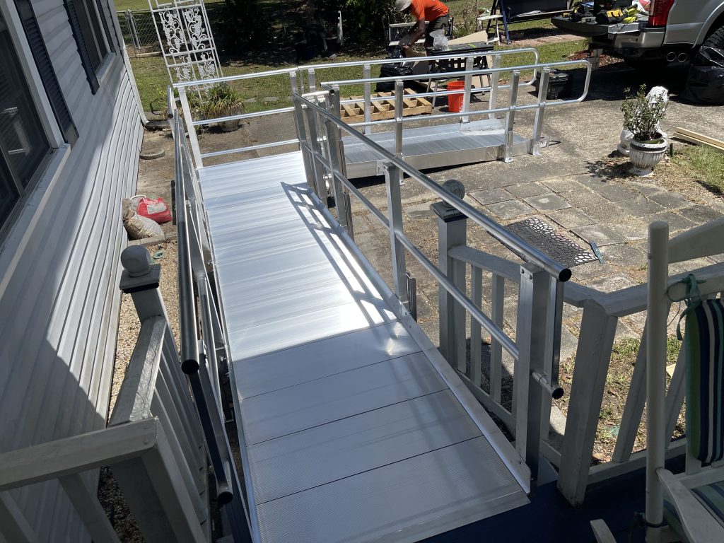 Modular aluminum wheelchair ramp system installed at a residential home in Abita Springs, LA with ADA-compliant handrails and non-slip decking surface.