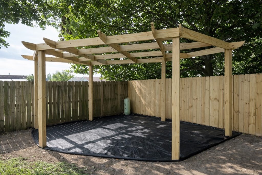 Custom freestanding wood pergola installed in Madisonville, Louisiana, featuring pressure-treated lumber and clean structural post alignment in a backyard setting.