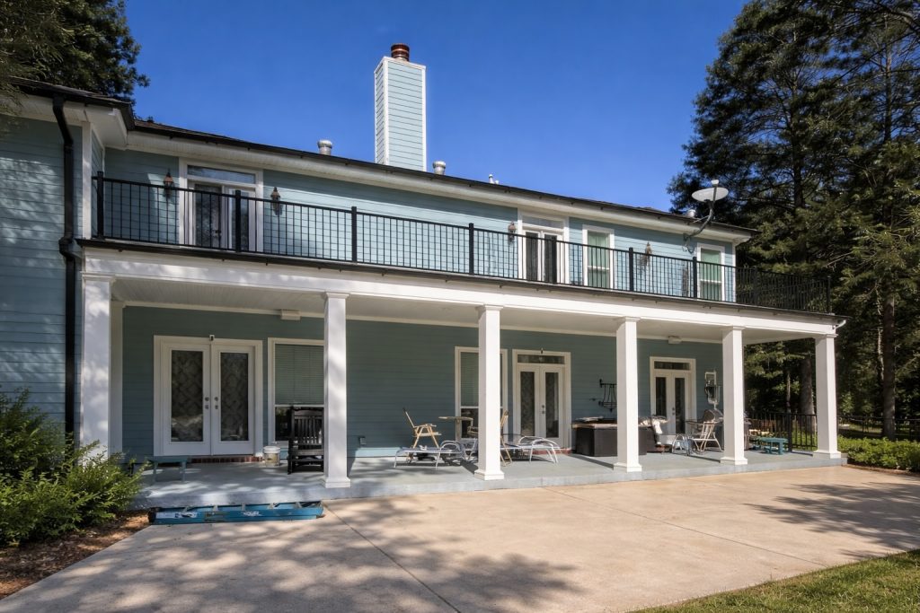 Elevated covered deck with black aluminum railing and patio below in Abita Springs Louisiana