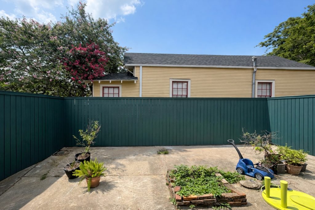 8-foot painted wood privacy fence installed in Madisonville, Louisiana, providing full backyard enclosure and clean vertical board design.
