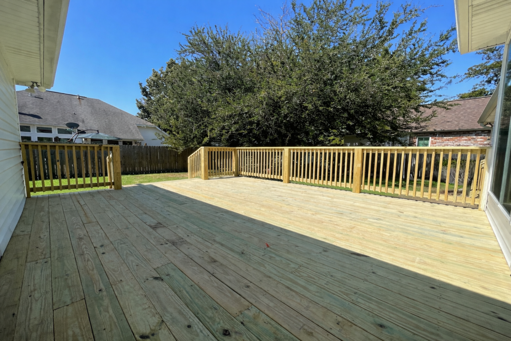 pressure treated wood deck installation with railing at residential backyard home in Covington Louisiana by GRC Outdoor Living