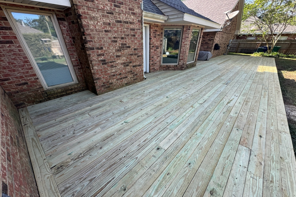 Pressure-treated wood deck installation at brick home in Covington Louisiana