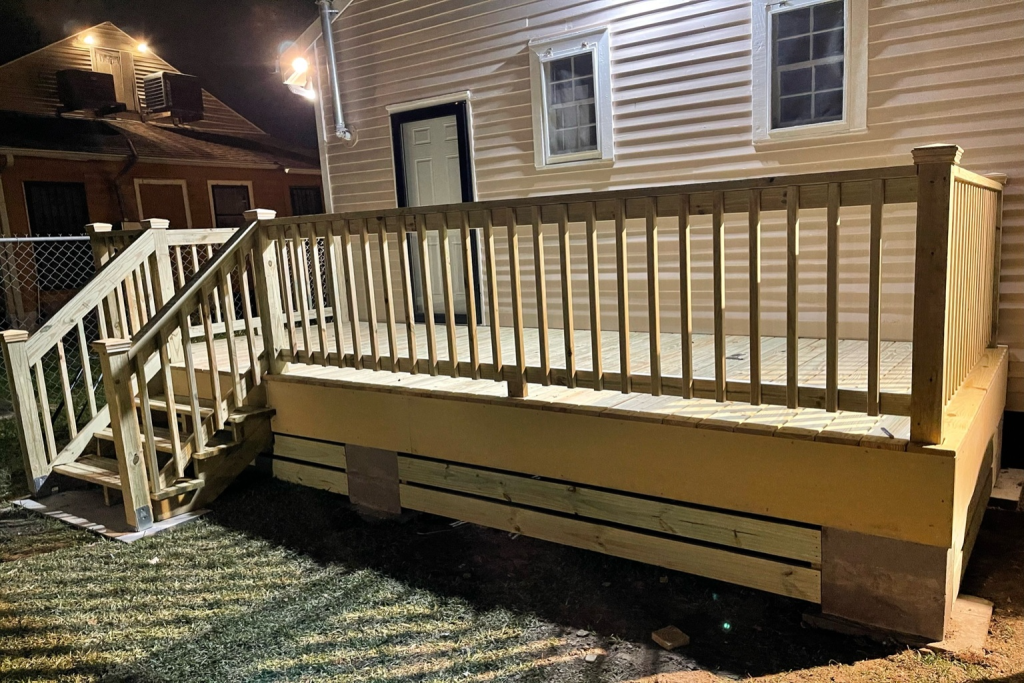 New pressure-treated wood deck with stair access and railing system installed in Abita Springs, LA for a residential backyard home.