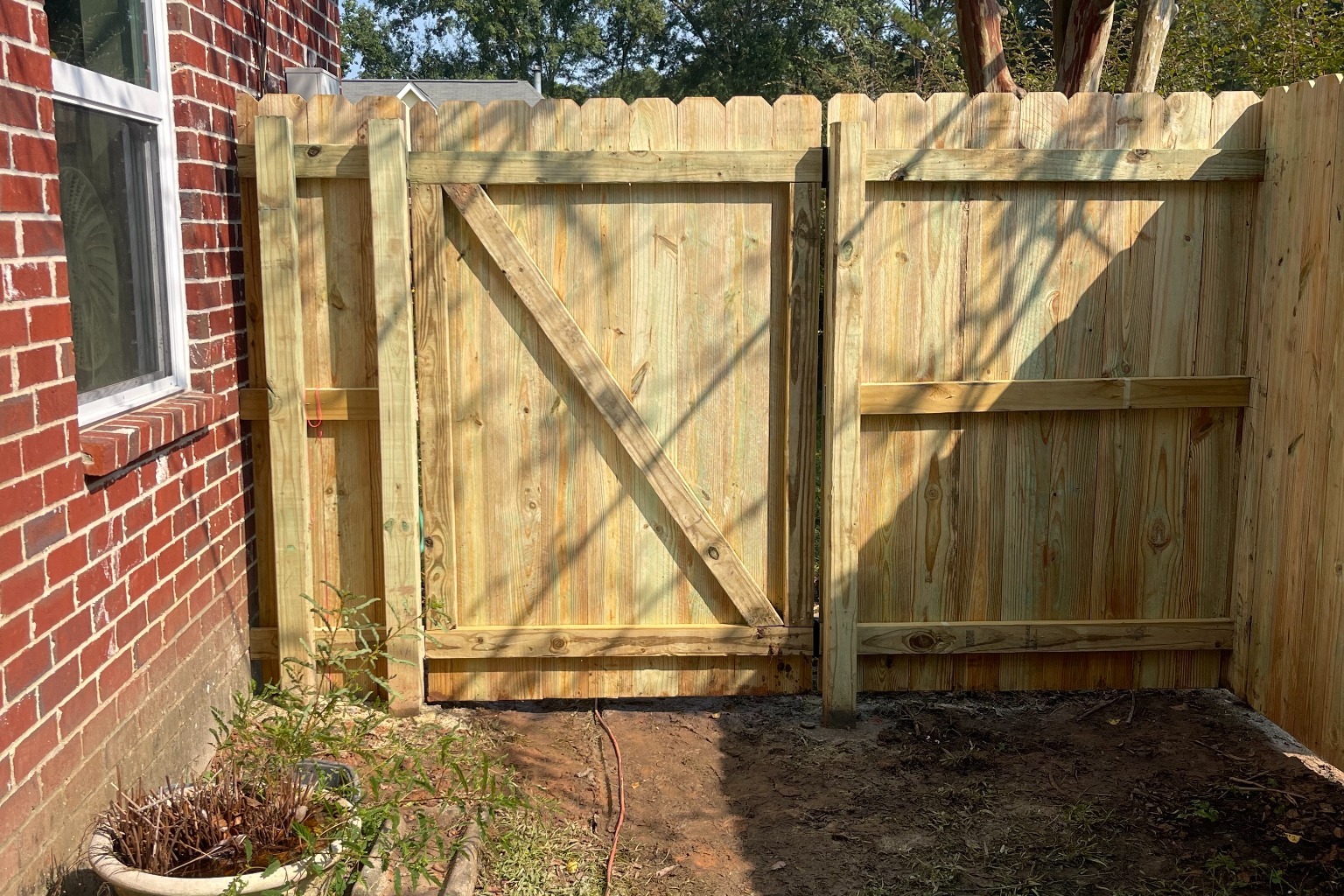 Professional pine privacy fence replacement with perfectly aligned boards in South Louisiana backyard.